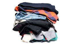 A stack of sweatshirts, sweaters, and other clothing on a white background