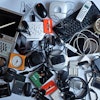 Keyboards, cassette tapes, a portable CD player, and other small electronics in a pile on a white background