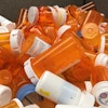 Close-up of orange and white prescription bottles in a pile