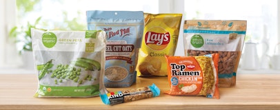 Snacks in packaging made of multi-layer plastic lined up on a countertop, including ramen, a Kind bar, and potato chips